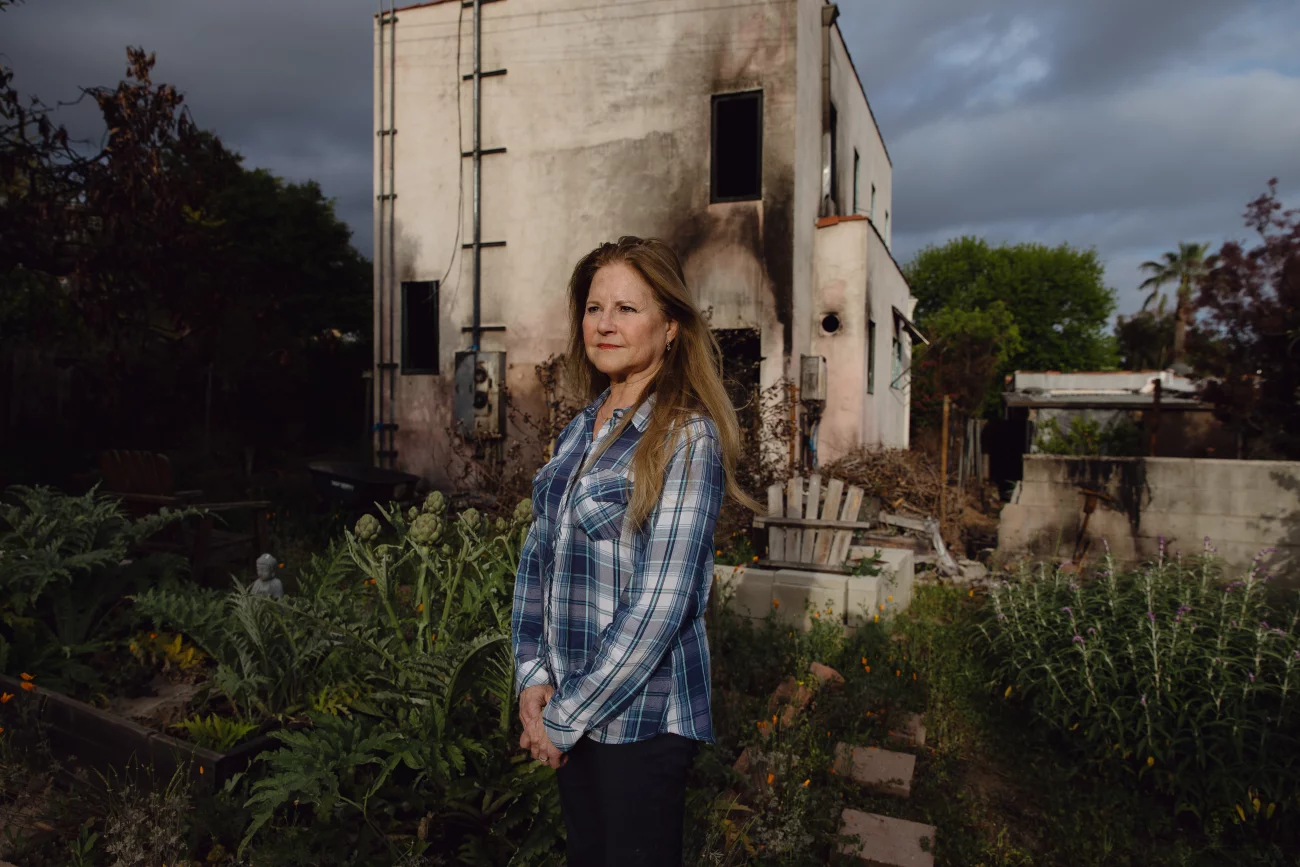Homeowner or resident surveying the damage and destruction to her house after a fire